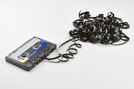 Vintage cassette tape with exposed tape isolated on white background. Concept with mental health protection by music. 