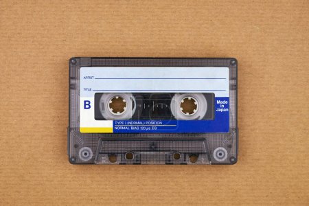 Retro cassette tape on a textured paper surface.