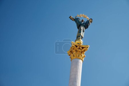 Monument of Independence of Ukraine The Statue of Berehynia standing on top of a column with a blue sky in the background.