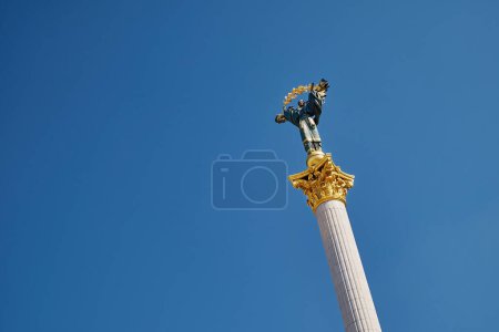 Monument of Independence of Ukraine The Statue of Berehynia standing on top of a column with a blue sky in the background.