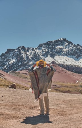 Téléchargez les photos : Femme debout dans la montagne Ausangate au Pérou avec toutes les montagnes des Andes en arrière-plan. altitude de 5200 mètres au dessus du niveau de la mer. - en image libre de droit