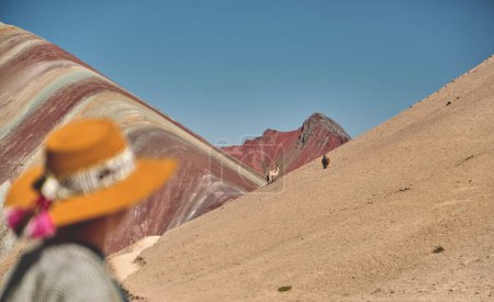 Téléchargez les photos : Femme debout dans la montagne Ausangate au Pérou avec toutes les montagnes des Andes en arrière-plan. altitude de 5200 mètres au dessus du niveau de la mer. - en image libre de droit