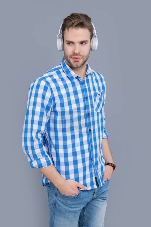 Handsome man listening to music in leisure time. Serious man wearing headphones for music. Audiophile studio isolated on grey. Music for leisure.