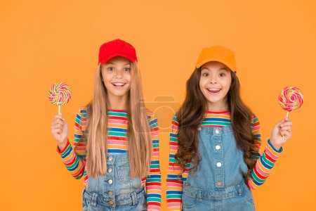 Photo for Express positivity. smiling sisters lollipop candy. kids have party fun. school friends celebrate holiday. candy shop concept. sweet life. happy childhood. positive and friendly. Happy childrens day. - Royalty Free Image