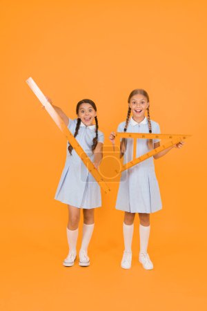 Photo for Geometric shapes. small girls love geometry. old school. modern education. happy friends in retro uniform. vintage kid fashion. back to school. girls hold math tools. smart children at stem lesson. - Royalty Free Image