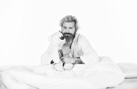 Photo for Mature man with toys in bed. feel childish. bearded man hipster play with bear. toys for adult. feeling happy and childlike. Psychological problems with imaginary friends. good morning. - Royalty Free Image