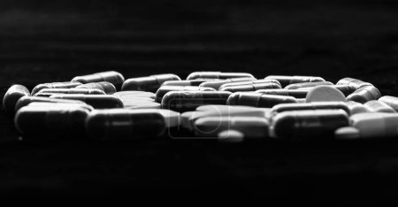 Téléchargez les photos : Amidon capsule pilules et comprimés fond sombre, médicaments. - en image libre de droit
