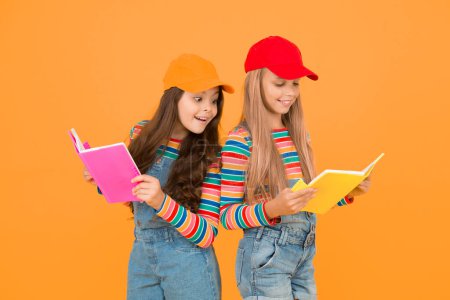 Photo for Kids girls with books study together. Study group can help solidify and clarify material. Back to school. Learning foreign languages. Effective study groups help students learn material deeper. - Royalty Free Image