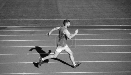 Foto de Enérgico atlético hombre musculoso corredor corriendo en pista de carreras en el estadio al aire libre, desafío. - Imagen libre de derechos