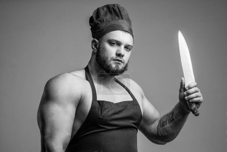 Foto de Hombre musculoso carnicero en delantal de chef cuchillo de cocina utensilio, cocina. - Imagen libre de derechos