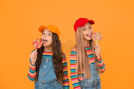 Photo for Fun and entertainment. Join celebration universal childrens day. Child care. Healthy nutrition sweet treats. Happy kids. Happy childrens day. Holiday celebration. Happy girls eating lollipop candy. - Royalty Free Image