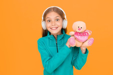 Photo for I love you with all my heart. Happy girl celebrate love. Little child wear earphones with teddy bear. Love you inscription. Spread love all over you go. Happy valentines day. Holiday celebration. - Royalty Free Image