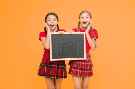 Photo for List of winners. information office. school project presentation. copy space. children presenting bulletin board. big sales. happy small girls with blackboard. place for announcement. - Royalty Free Image