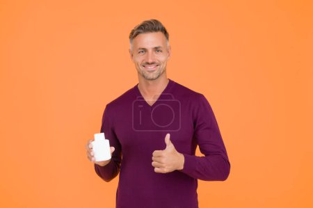 Photo for Product for sale. Happy guy give thumbs up to product. Handsome man presenting product. Product promotion. Bottle or container for advertising text, copy space. - Royalty Free Image