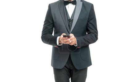 Photo for Tuxedo man messaging on smartphone isolated on white background. - Royalty Free Image