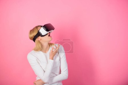 Foto de Mujer con auriculares de realidad virtual. Mujer joven usando un auricular de realidad virtual. Jovencita divertida con VR. Esquema de los juegos - Imagen libre de derechos