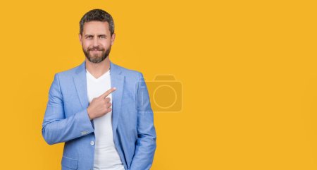 businessman wearing formal jacket directing. caucasian businessman in jacket isolated on yellow background. businessman in studio. photo of handsome businessman wear suit.