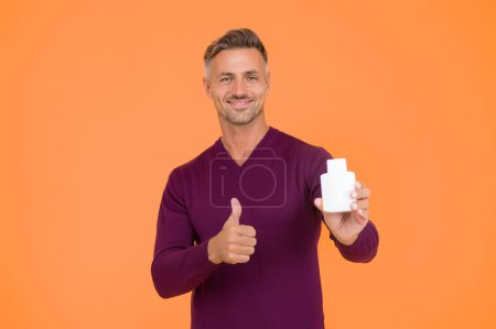 Photo for Favorite lotion after shaving. Worth to try. Cosmetics for men. Beauty product. Handsome well groomed healthy guy recommend product. Body care. Presenting product. Mature man pointing at bottle. - Royalty Free Image