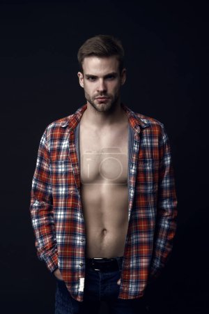 Attractive and desirable. Sexy worker. Man sexy muscular torso wear checkered shirt. Western style. Macho on black background. Handsome man with beard. Male fashion. Casually sexy. Feeling confident.