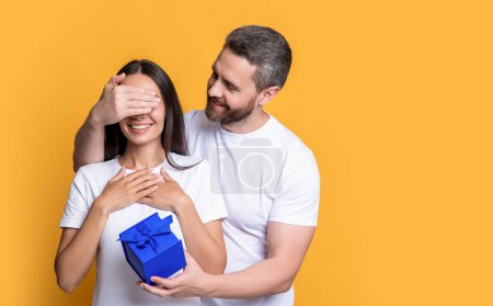 Photo for Couple with surprise present, copy space. holiday couple with surprise present box. photo of couple with present for holiday. womens day. surprise couple with present isolated on yellow background. - Royalty Free Image