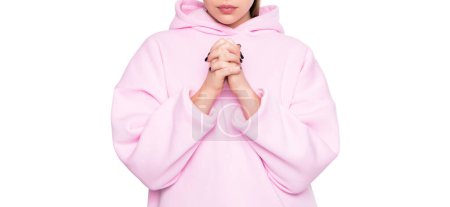Téléchargez les photos : Femme religieuse vue de la récolte dans casual sweat à capuche rose en gardant les mains jointes pour prier isolé sur blanc. - en image libre de droit