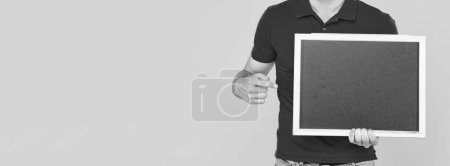 Photo for Cropped guy with bristle point finger on chalkboard with copy space on yellow background, announcement. - Royalty Free Image