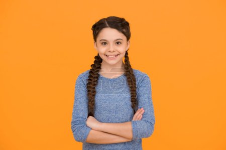 Photo for Hair braided in braids. little beauty with crossed hands. happy childhood. small girl has nice smile. kid hairstyle fashion. smiling child with long hairdo. cheerful teen after hairdresser. - Royalty Free Image