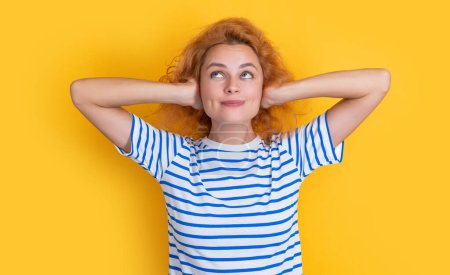 Photo for Cheerful redhead girl hear loud noisy sound isolated on yellow background. young girl hear loud noisy sound in studio. sound is too loud and noisy for girl hear, - Royalty Free Image