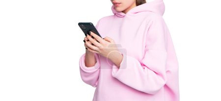 Mädchen in lässigem rosa Kapuzenpulli mit Smartphone auf weißen, mobilen sozialen Medien.