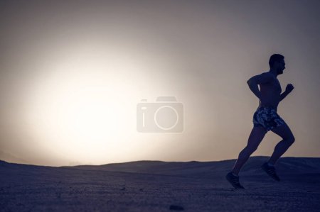 Photo for Man silhouette, running guy on sunset fiery sky background in mountain, sport and recreation, future and success, people and nature, speed and healthy lifestyle, copy space - Royalty Free Image