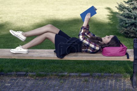 Photo for Reading is fun. Happy child read book lying on park bench. School library. Imagination and fantasy. Literacy education. Back to school supplies. Afterschool activites. Reading is never boring. - Royalty Free Image
