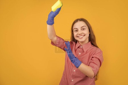 Téléchargez les photos : Heureux enfant dans des gants en caoutchouc avec éponge sur fond jaune. - en image libre de droit