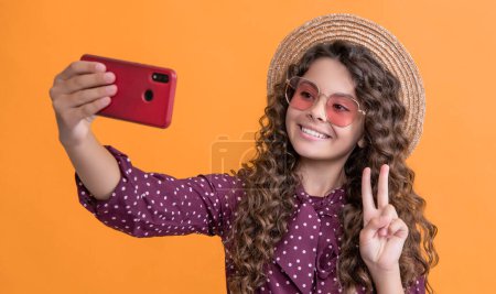 Foto de Happy girl with curly hair taking selfie on phone. peace. - Imagen libre de derechos