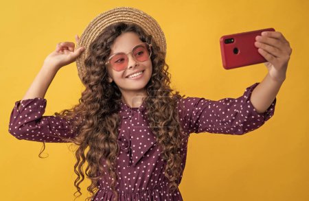Foto de Smiling girl with curly hair taking selfie on phone. - Imagen libre de derechos