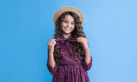 Photo for Glad child in straw hat with long brunette curly hair on blue background. - Royalty Free Image