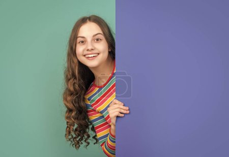 Photo for Glad girl behind blank blue paper with copy space for advertisement. - Royalty Free Image