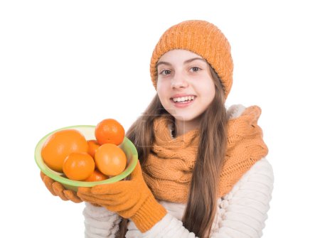 Photo for Teen girl need vitamins in winter. childhood happiness. small kid wear knitted scarf and gloves. child in hat and sweater hold citrus fruits. autumn fashion style. warm clothes. healthy lifestyle. - Royalty Free Image