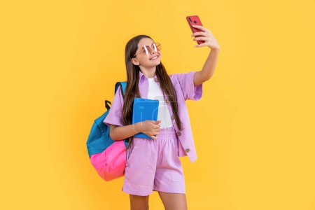 Photo for Selfie teen school girl in studio. selfie teen school girl on background. photo of selfie teen school girl with phone. selfie teen school girl isolated on yellow. - Royalty Free Image