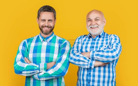 Photo for Happy two generation family men in studio. two generation family men on background. photo of two generation family men wear checkered shirt. two generation family men isolated on yellow. - Royalty Free Image