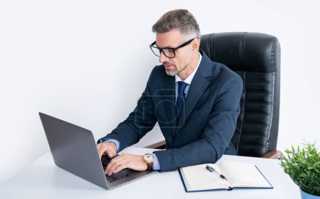 Téléchargez les photos : Homme d'affaires mature assis dans un bureau d'affaires avec ordinateur. - en image libre de droit