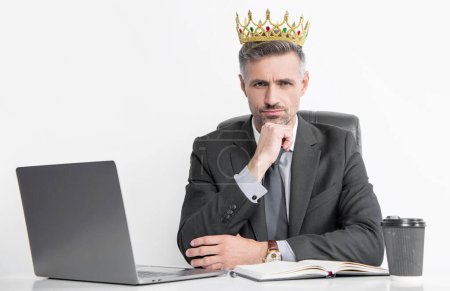 ambitious mature businessman in suit and crown at the office.