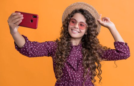 Foto de Smiling girl with curly hair taking selfie on phone. - Imagen libre de derechos