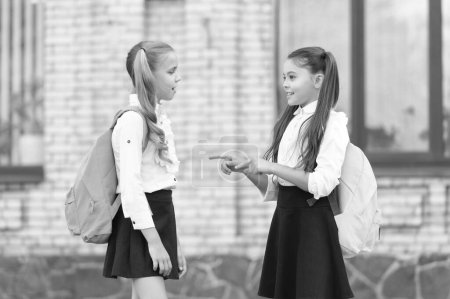 Photo for Two school girls friends talking together duting school break. - Royalty Free Image
