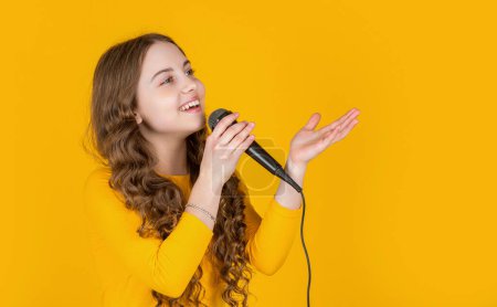 Foto de Chica de la música con micrófono sobre fondo amarillo. - Imagen libre de derechos