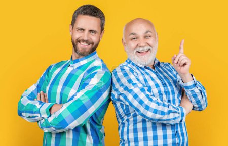 Photo for Two generation family men in studio, inspired. two generation family men on background. photo of two generation family men wear checkered shirt. two generation family men isolated on yellow. - Royalty Free Image