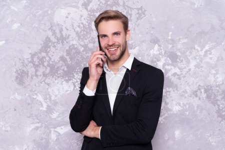 Photo for Happy business man talk on phone. photo of business man talk on phone wear suit. successful business man talk on phone isolated on grey. business man talk on phone in studio. - Royalty Free Image