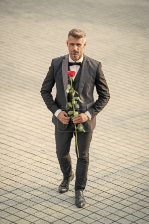 Téléchargez les photos : Engagement date. tuxedo man celebrates engagement. man with rose gift for engagement. - en image libre de droit