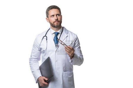 Photo for Pondering doctor presenting emedicine on background. emedicine and doctor man with laptop. doctor promoting emedicine isolated on white. doctor offering emedicine in studio. - Royalty Free Image