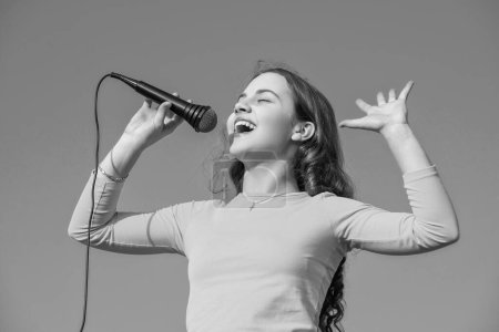 Foto de Happy teen child singing karaoke in microphone. - Imagen libre de derechos