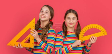 Photo for Smiling school students hold math tool of triangle and protractor. - Royalty Free Image